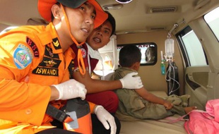 Des secouristes indonésiens prennent en charge un survivant après le naufrage d'un ferry sur l'île de Sulawesi le 20 décembre 2015