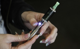 Illustration: une femme tenant une cigarette électronique.