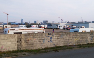 Dissimulé par un mur, le terrain occupé par les familles roms se trouve le long du quai Wilson, sur l'île de Nantes.