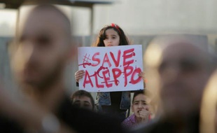 Une jeune Syrienne tient une pancarte "Sauvez Alep", lors d'un rassemblement de solidarité dans la ville libanaise de Tripoli, le 1er mai 2016
