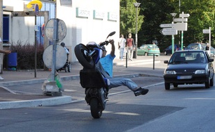 Illustration. Jeune à scooter en roue arrière dans la circulation
