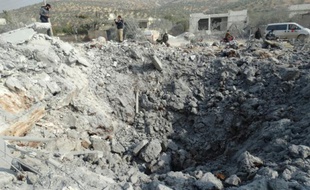 Des Syriens inspectent un cratère après un raid de la coalition, dans la ville de Harem, en Syrie, le 19 novembre 2014