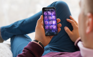 (Illustration) Un homme consulte son horoscope sur son téléphone