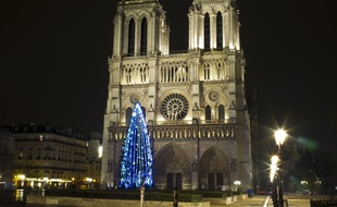 Un grand sapin de noël devant Notre-Dame de Paris.