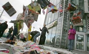 L'organisation Résistance à l'agression publicitaire (RAP) déverse des prospectus, le 09 décembre 2006 devant un centre commercial à Paris, lors d'une action de résistance à l'agression publicitaire pour protester contre les publicités distribuées dans les boîtes aux lettres