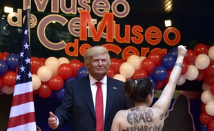 Une militante des Femen attrape les parties de la statue de cire du président américain élu, Donald Trump, au Musée de Cire de Madrid, le 17 janvier 2017.