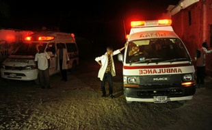 Des ambulances sur les lieux d'une explosion provoquée par une voiture piégée devant un restaurant, le 21 janvier 2016 sur la plage du Lido, à Mogadiscio, en Somalie