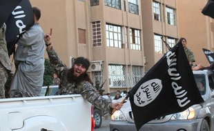 Image extraite du média jihadiste Al-Baraka news, le 11 juin 2014, montrant des militants de l'EI et leur drapeau noir dans la ville syrienne de Raga