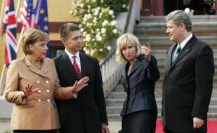 La chancelière Angela Merkel (G) et son mari Joachim Sauer accueillentle Premier ministre canadien Stephen Harper (D) et sa femme Laureen, avant l'ouverture du sommet par un dîner à Hohen Luckow, le 6 juin 2007.