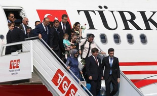 Le Premier ministre Ahmet Davutoglu au centre et sa femme Sare Davutoglu (g) à l'aéroport d'Ankara avec les ex-otages, le 20 septembre 2014
