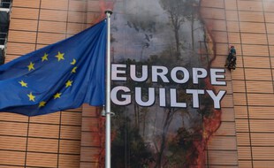 Des activistes de Greenpeace déroulent une bannière, au QG de l'Union européenne, pour alerter sur la déforestation en cours dans la forêt amazonienne et la part de responsabilité de l'Union européenne via ses importations.