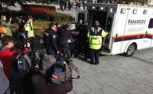 Ambulanciers et policiers s'occupent d'une personne blessée par des tirs au Mémorial de la Guerre à Ottawa (Canada) le 22 octobre 2014