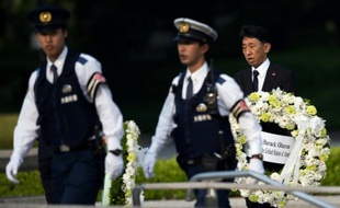 Un homme porte la couronne qui va être déposée par le président Obama lors de sa visite à Hiroshima, le 27 mai 2016