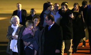 Le président Francois Hollande parle avec Albane Moulin-Fournier, qui porte l'un de ses enfants, devant les autres membres de la fammile Moulin-Fournier, qui viennent d'arriver de Yaoundé à Orly, le 20 avril 2013.