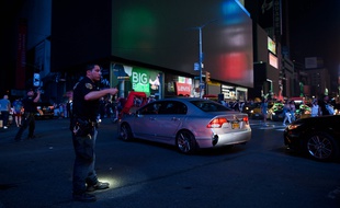Un policier régule le trafic pendant une coupure de courant à Times Square, New York, le 13 juillet 2019.