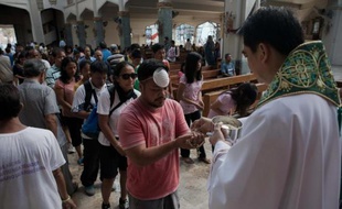 Des survivants en deuil du typhon meurtrier qui a ravagé les Philippines, pays majoritairement catholique, tentaient de trouver un peu de réconfort et d'espoir dimanche dans les églises dévastées.