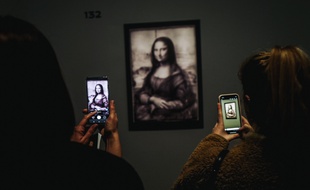 Des visiteurs prennent en photo le premier dessin de "La Joconde" par Léonard de Vinci, révélé par la réflectographie infrarouge