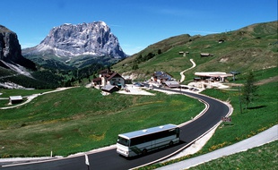Illustration d'un car roulant dans les Alpes.