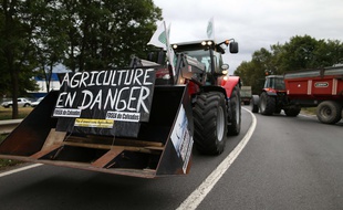 Un agriculteur bloque une rute avec son tracteur, à Verson, près de Caen, le 19 juillet 2015.