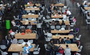 Des réfugiés installés à table dans un hall à Munich, en Allemagne le 7 septembre 2015.