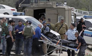 Les forces de sécurité israéliennes transportent le 8 avril 2015 le corps d'un Palestinien à Sinjil (Cisjordanie), responsable de l'agression de deux soldats israéliens