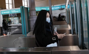 Une femme porte un masque à l'entrée d'une station du RER B à Paris, le 6 mars 2020.