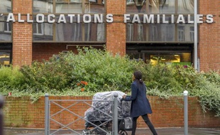 Une femme poussant un landau passe devant la Caisse d'allocations familiales à Lille le 8 octobre 2014