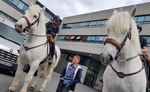 Erwan pose fièrement avec les cavaliers de la brigade équestre.