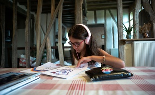 Jeune fille (agee de 10 ans) en vacances, ecoutant de la musique sur son lecteur MP3. Gers, France, 7 Aout 2017.