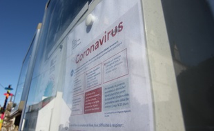 Illustration d'une affiche évoquant le coronavirus devant une école bretonne.