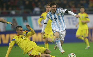 Le défenseur roumain Dragos Grigore tacle l'attaquant argentin Lionel Messi, lors du match amical Roumanie - Argentine (0-0), le 5 mars 2014 à Bucarest.