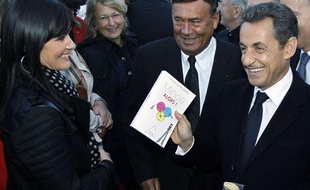 Nicolas Sarkozy se fait offrir un livre où est inscrit «Mince alors» lors de la visite d'un centre de tri des déchets près de Laval, en Mayenne, le 20 octobre 2011, au lendemain de l'accouchement de son épouse, Carla Bruni-Sarkozy.