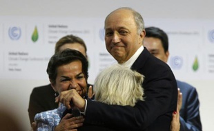 Le président de la COP21, Laurent Fabius (d) avec l'ambassadrice française Laurence Tubiana (de dos) et la responsable climat de l'ONU Christiana Figueres (g), à Paris le 12 décembre 2015
