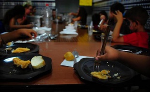 Pendant que d'autres terminent leurs vacances, une vingtaine d'écoliers reçoivent avec fierté leur diplôme dans une école espagnole de Séville, l'une des dizaines qui sont restées ouvertes pendant l'été pour assurer le repas à des enfants touchés par la crise.