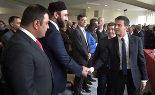 Le premier ministre Manuel Valls (d) accompagné par le Président de la Grande Mosquée de Strasbourg, Ali El-Jarroudi (derrière), serre la main de la communauté religieuse musulmane à la Grande mosquée de Strasbourg, le 3 mars 2015.. AFP PHOTO / PATRICK HERTZOG
