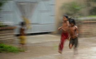 Des enfants sous la pluie à Dacca, au Bangladesh, le 28 avril 2010