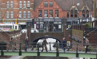 Des passants traversent un pont sur un canal à Birmingham, dans le centre de l'Angleterre, le 14 mars 2015