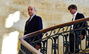 Alain Juppé, suivi par son adjoint aux finances Nicolas Florian descend le grand escalier de l'hôtel de ville.