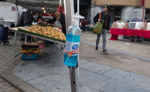 Du gal hydroalcoolique sur un marché de Bruxelles, en Belgique.