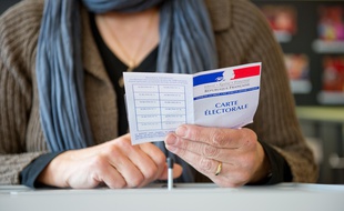 Une personne tenant une carte électorale.