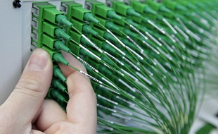 Illustration d'un technicien intervenant sur une armoire de raccordement à la fibre optique.