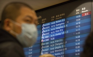 Un panneau à l'aéroport de Pékin affiche un vol en provenance de Wuhan annulé, le 23 janvier 2020.
