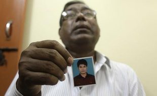 Le père de Quazi Mohammad Rezwanul Ahsan Nafis tient une photo de son fils, accusé d'avoir préparé un attentat terroriste à New York, le 18 octobre 2012, à Dacca (Bangladesh).
