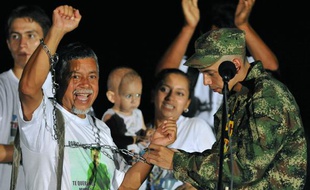 Le sergent colombien Pablo Emilio Moncayo (D) qui vient d'être libéré par les Farc, retire les chaînes que son père Gustavo Moncayo porte symboliquement depuis plusieurs années, à l'aéroport de Florencia le 30 mars 2010.