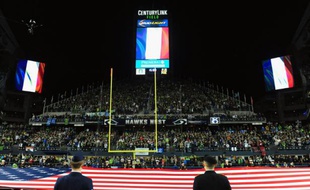 Des drapeaux français sont hissés, le 15 novembre 2015 dans un stade à Seattle en hommage aux victimes des attaques de Paris