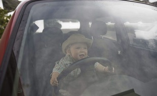 Un enfant joue dans une voiture. (illustration)