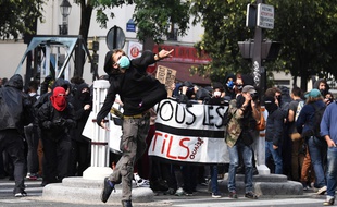 Un jeune homme lance un projectile lors de la manifestation contre la réforme du Code du travail, mardi 12 septembre à Paris.