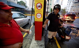 Un motocycliste paie son essence à Caracas, le 17 février 2016.