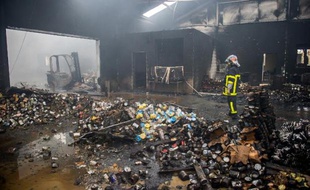 Un pompier dans un entrepôt des Restos du Coeur détruit par un incendie, le 2 décembre 2014 à Vendin-le-Vieil, près de Lens dans le Pas-de-Calais