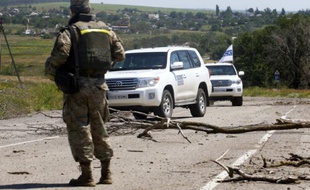 Des véhicules de l'OSCE à leur arrivée le 4 juillet 2015 dans le village de Shyrokyne dans la région de Donetsk